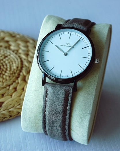 Christopher Kingsley watch on wrist with grey leather band, displayed on fabric holder