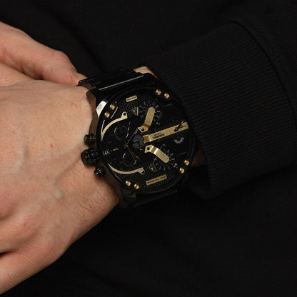 Close-up of black chronograph watch with multiple dials and gold-tone hands worn on wrist