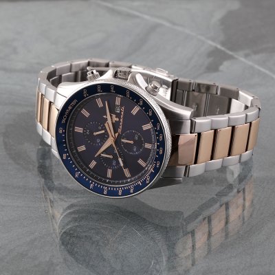 Maserati Sfida chronograph at angle on reflective surface with blue dial and two-tone bracelet