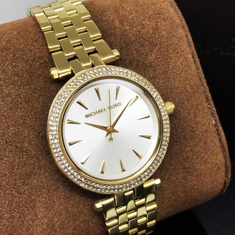 Michael Kors Darci all-gold watch on wrist with crystal bezel