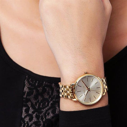 Michael Kors Pyper watch on wrist featuring cream dial and gold-tone bracelet strap
