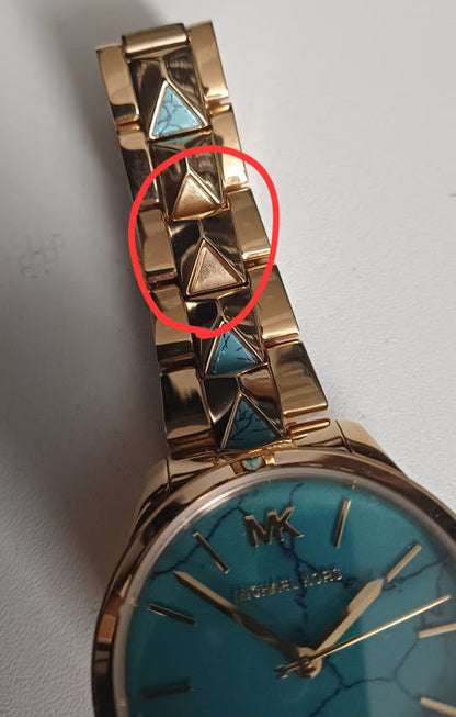 Michael Kors Runway Mercer watch detail showing defect in turquoise triangle link