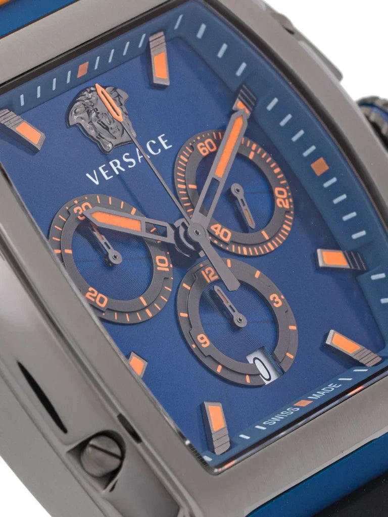 Close-up of Versace Dominus blue dial with orange chronograph subdials, hour markers, and Versace logo