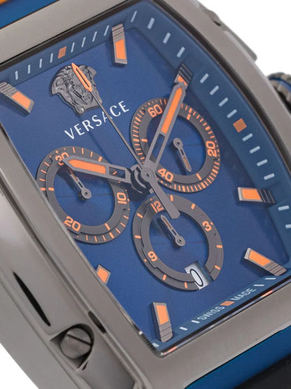 Close-up of Versace Dominus blue dial with orange chronograph subdials, hour markers, and Versace logo