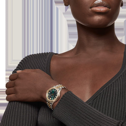 Versace Hellenyium women's watch worn on wrist, showing green dial and two-tone steel strap