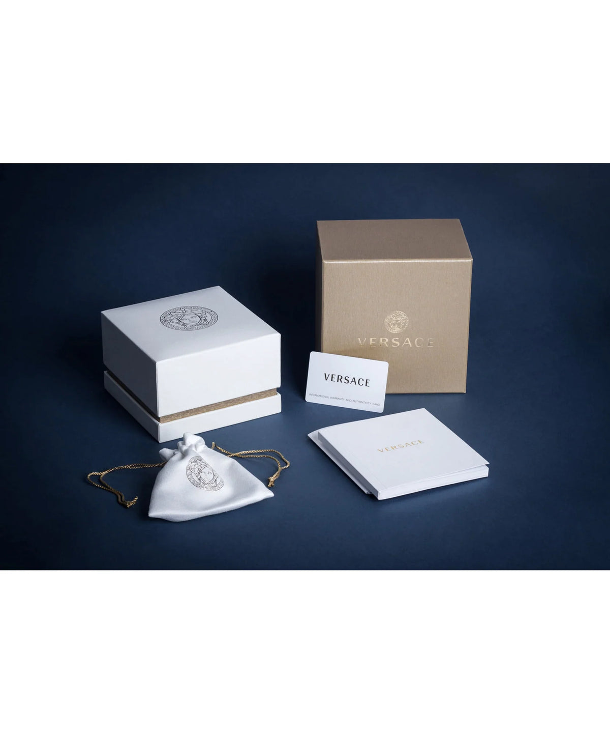 Versace jewelry set with packaging on a dark blue background